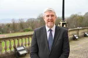 Finance Minister John O'Dowd standing outside Parliament Buildings at Stormont