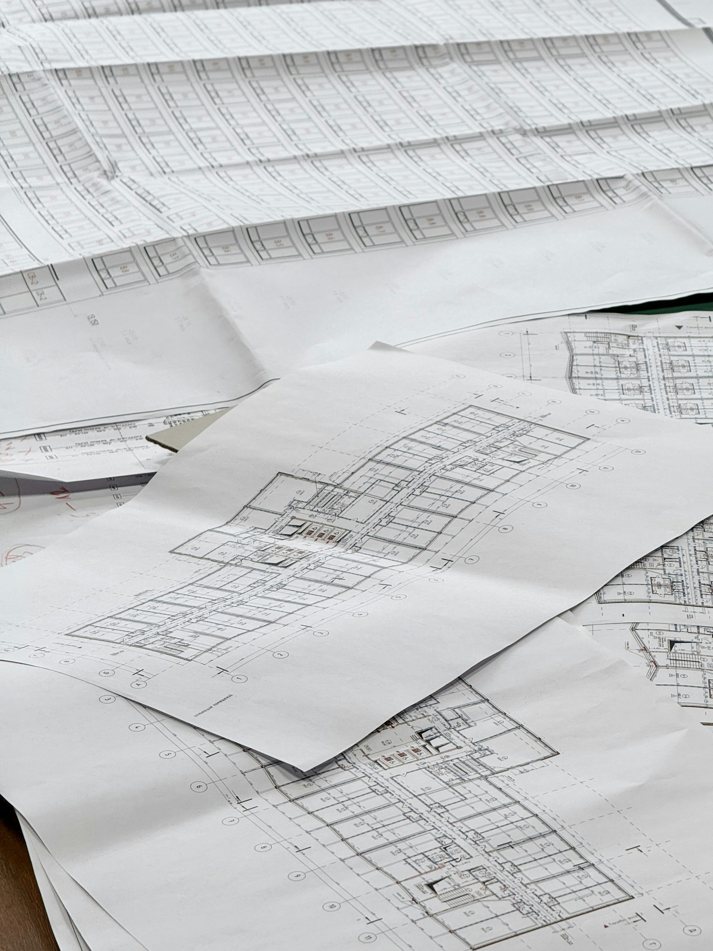 Architectural plans and development drawings spread across a work surface