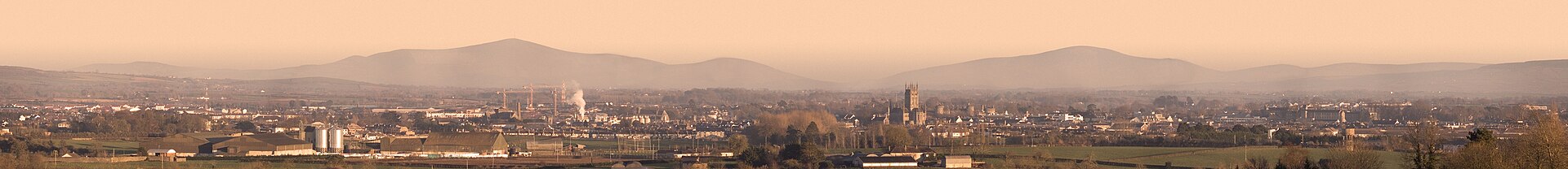 A panorama of Kilkenny city, county Kilkenny, Ireland, taken from about 4km west of the city.The church in the centre is St. Mary's cathedral (Roman Catholic).Just to the right of it is Kilkenny castle.The two mountains in the background are from left, Mt. Leinster (TV transmitter on top) and Blacks