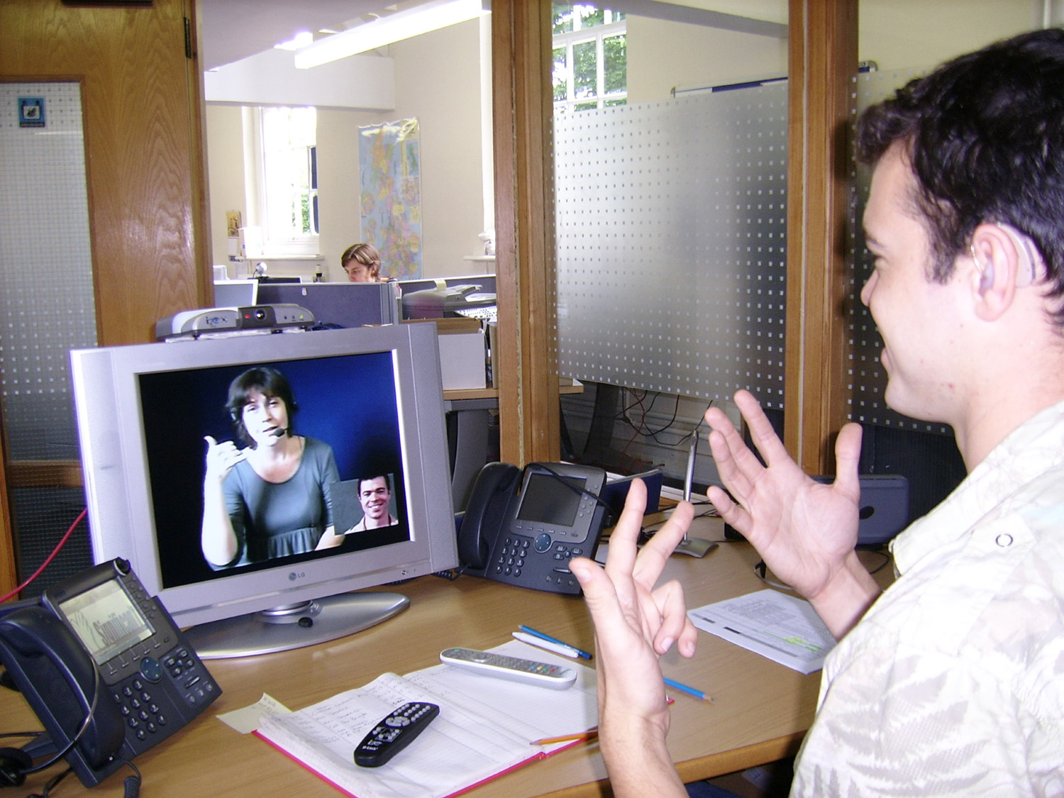 A Deaf worker using sign language during a video interpreting call